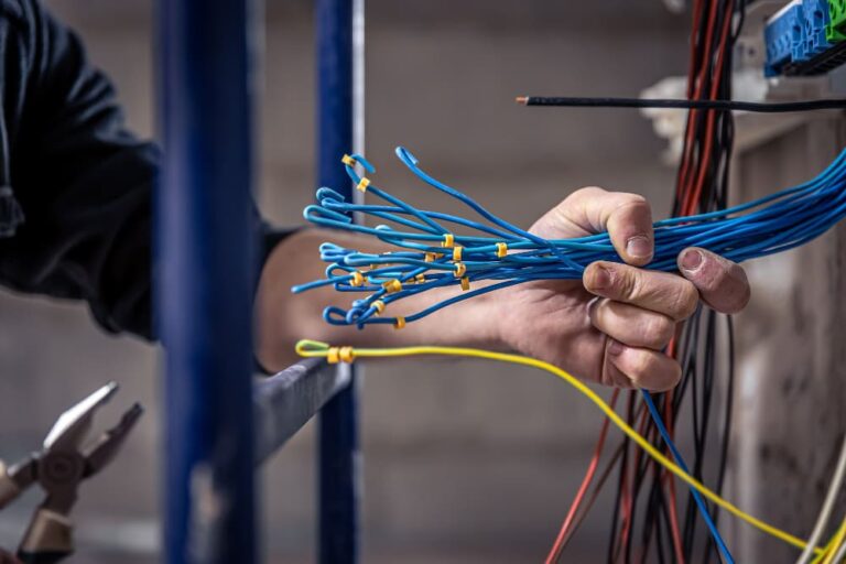 Image d'un électricien raccordant des câbles électriques.