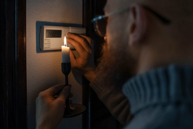 Homme utilisant une lampe de poche pendant une panne de courant.