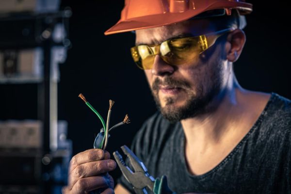 Image d'un électricien travaillant dans un tableau de câblage pour une connexion électrique.